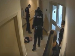 Ottawa Police Service Const. Goran Beric, centre, is seen holding his baton after a takedown inside an Ottawa Community Housing complex on Aug. 4, 2021.