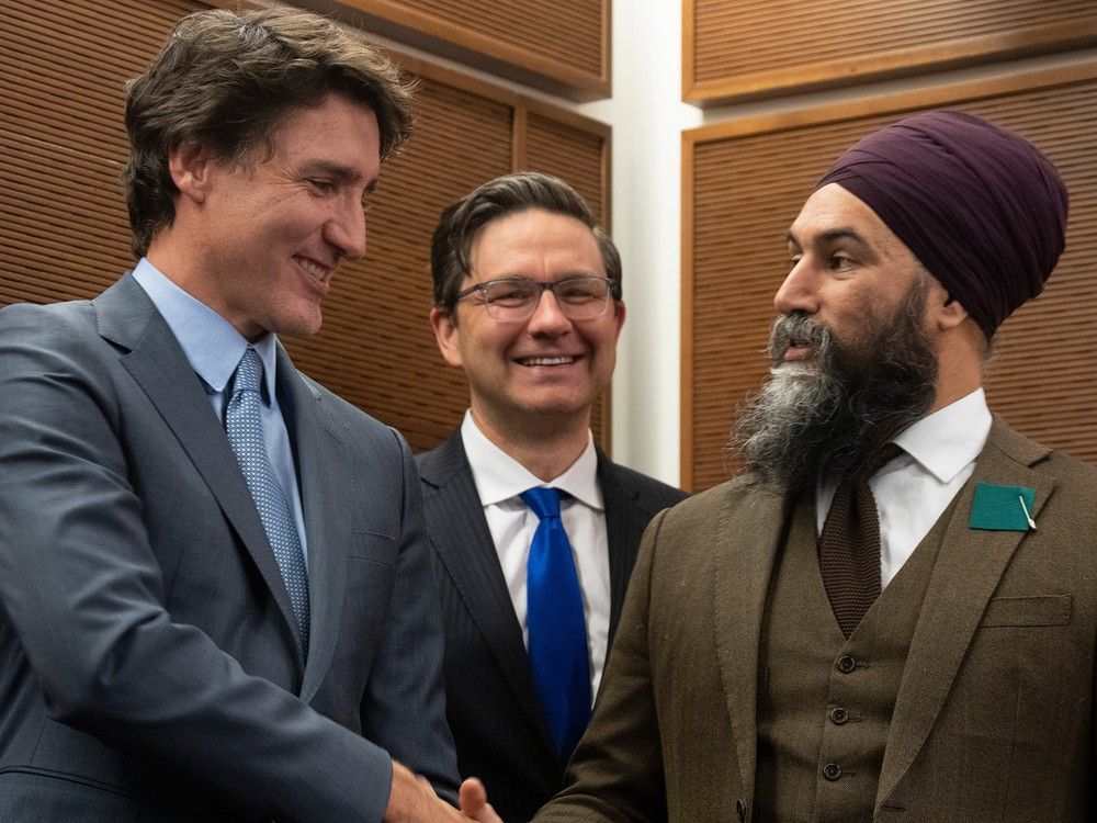 El primer ministro Justin Trudeau le da la mano al líder del Nuevo Partido Demócrata, Jagmeet Singh, mientras el líder conservador Pierre Poilievre observa una recepción del Mes de la Herencia Tamil, el lunes 30 de enero de 2023 en Ottawa.