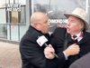 An RCMP officer grabs David Menzies from Rebel News