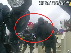 This image from police body-worn camera video, and contained and annotated in the Justice Department's sentencing memorandum, shows Kenneth Bonawitz colliding with two officer at the U.S. Capitol on Jan. 6, 2021, in Washington. Bonawitz, who assaulted at least six police officers during a mob's attack on the U.S. Capitol, has been sentenced to five years in prison. (Department of Justice via AP)
