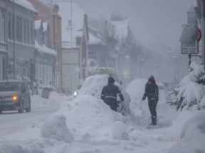 People clearing snow from vehicle in stormy Norway
