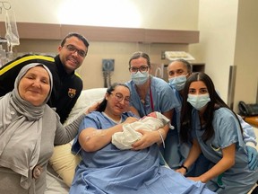 Mother Zaineb Ben Elhadj Taher holds her newborn daughter surrounded by her husband and hospital staff at St. Mary's Hospital.