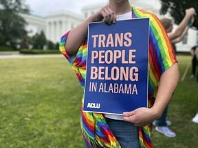 FILE - A person holds up a sign reading, "Trans People Belong in Alabama," during a rally outside the Alabama Statehouse in Montgomery, Ala., on International Transgender Day of Visibility, Friday, March 31, 2023. Alabama can begin immediately enforcing a ban outlawing the use of puberty blockers and hormones to treat transgender people under 19, a federal appeals court ruled Thursday, Jan. 11, 2024, granting the state's request to stay a preliminary injunction that had blocked enforcement of the 2022 law.