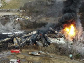FILE - Portions of a Norfolk Southern freight train that derailed the night before burn in East Palestine, Ohio, Feb. 4, 2023. About 1,000 engineers and conductors who work for Norfolk Southern will soon be able to report safety concerns anonymously through a federal system without any fear of discipline.