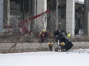 Emergency crews work to retrieve a car that crashed through the ice into the Keating Channel in Toronto, on Saturday Jan. 20, 2024.