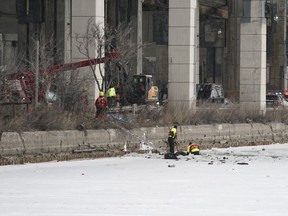 Emergency crews work to retrieve a car that crashed through the ice into the Keating Channel in Toronto on Saturday.
