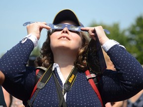 Canada's largest school board is voting Wednesday on whether it should revise its school calendar so students can stay home on the day a rare solar eclipse will partially and, for a fleeting few minutes in some areas, totally dim daylight. Observers watch a solar eclipse at the Canadian National Exhibition in Toronto on Monday, August 21, 2017.