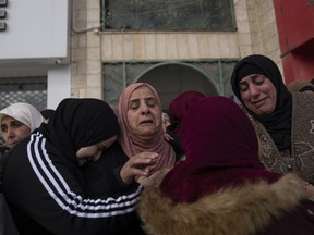Palestinian women cry at a funeral.