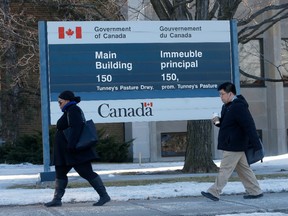 People walk past a Government of Canada building.