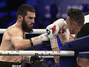 Artur Beterbiev, left, and Callum Smith fight for world unified light heavyweight boxing match, in Quebec City, Saturday, Jan. 13, 2024.