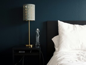 Bed with white bedding in front of dark blue wall