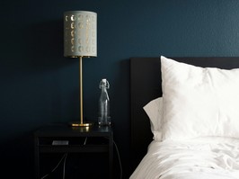 Bed with white bedding in front of dark blue wall