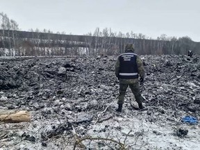 In this photo taken from video released by Russian Investigative Committee on Thursday, Jan. 25, 2024, an investigator walks in a field where a Russian military transport crashed a day earlier near Yablonovo, in the Belgorod region of Russia. The Russian Defense Ministry said Ukraine shot down the plane carrying Ukrainian prisoners of war. Although Russia has released what it called evidence that it said proved Ukrainian POWs were aboard, officials in Kyiv disputed it and instead blamed Moscow for trying to use the incident to hurt Ukrainian morale. (Russian Investigative Committee via AP, File)