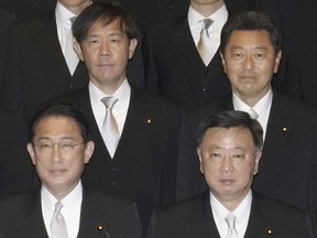 Japan's Lower House member Yoshitaka Ikeda, rear right, poses for a photograph with Prime Minister Fumio Kishida, bottom left, as he is sworn in as vice-education minister at Kishida's office in Tokyo, on Nov. 11, 2021. Tokyo District Public Prosecutors Office arrested Ikeda on Sunday, Jan. 7, 2024 on suspicion of failing to report fundraising proceeds he received from his faction within the governing Liberal Democratic Party, according to officials and local media reports. (Kyodo News via AP)