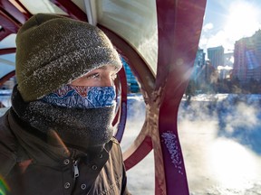 A man looks at the frozen Bow River in downtown Calgary.