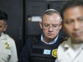 Former Interior Minister Napoleon Barrientos is escorted by police as he waits for his hearing at court in Guatemala City, Thursday, Jan. 11, 2024. Barrientos was arrested Thursday for allegedly not carrying out his duties when he opted for dialogue with protesters rather than using force to remove them as a court had ordered.