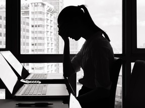 A photographic image of a stressed businesswoman sitting at a desk.