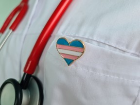 A doctor wears a transgender LGBT symbol with a stethoscope.