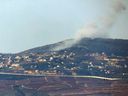 An Israeli position along the border with southern Lebanon shows smoke billowing above the Lebanese village of Adaisseh on Feb. 12, 2024. (