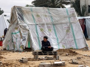 Palestinian child outside tent in Rafah