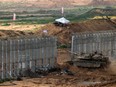 An Israeli tank crosses the border into northern Gaza on Monday.