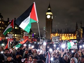 Pro-Palestinian demonstrators wave Palestinian flags and hold placards as they protest in Parliament Square in London on Feb. 21, 2024, during an Opposition Day motion in the the House of Commons calling for an immediate ceasefire in Gaza.
