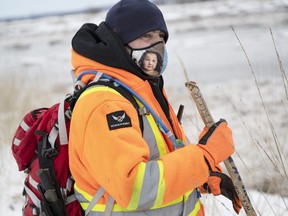 Wearing a mask with a photo of Dylan, Jason Ehler probes knee-deep snow along the Salmon River on Jan. 9, 2022.