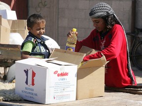 Palestinian children pack food aid from the United Nations Relief and Works Agency (UNRWA) in Rafah in southern Gaza in a file photo from Oct. 16, 2008.