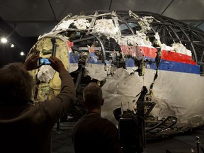 FILE - Journalists take images of part of the reconstructed forward section of the fuselage after the presentation of the Dutch Safety Board's final report into what caused Malaysia Airlines Flight 17 to break up high over Eastern Ukraine, during a press conference in Gilze-Rijen, Netherlands, Tuesday, Oct. 13, 2015 The Dutch government has spent more than 166 million euros ($180 million) dealing with the aftermath of the downing of Malaysia Airlines flight MH17 over eastern Ukraine in 2014 -- from repatriating victims' bodies to investigating and prosecuting some of those involved in the downing, according to an official report Thursday, Feb. 29, 2024.