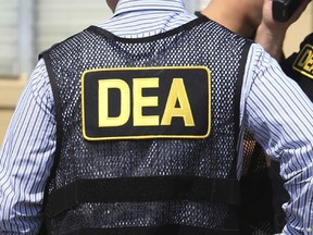 Man wearing a vest that reads "DEA"