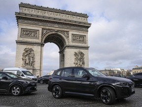 SUV car drive on the Champs Elysees avenue, near to the Arc de Triomphe.