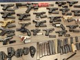 Dozens of handguns on a table.