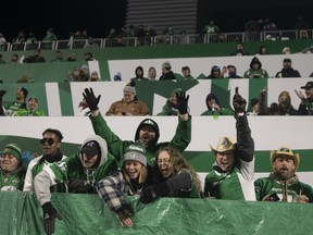 Saskatchewan Roughriders fans celebrate after a successful play in the second half of CFL football action against the Calgary Stampeders, in Regina, Sunday, Nov. 28, 2021. The Saskatchewan Roughriders apologized Wednesday for issuing a email to season-ticket holders that resulted in a backlash from fans.