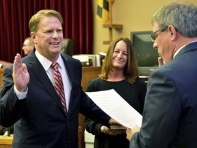 FILE - Washington County Circuit Court Clerk Kevin Tucker, right, swears in Andrew F. Wilkinson as a circuit court judge, Jan. 10, 2020, as Wilkinson's wife, Stephanie, watches. The Maryland Senate has voted for a measure to protect judges by creating a way for them to request shielding personal information online that could enable a hostile person to track them down. The vote Thursday, Feb. 8, 2024 came after the Maryland judge was shot to death in his driveway in October after ruling against the gunman.