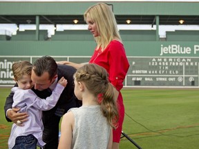 FILE - Boston Red Sox pitcher Tim Wakefield, center left, hugs his son, Trevor, 7, as his wife, Stacy, right, and daughter, Brianna, 6, look on after Wakefield announced his retirement from baseball during a news conference, Friday, Feb. 17, 2012, in Fort Myers, Fla. Stacy Wakefield, the widow of former Boston Red Sox pitcher and two-time World Series champion Tim Wakefield, has died. Wakefield's family said in a statement released through the Red Sox that she died Wednesday, Feb. 28, 2024 at her Massachusetts home, less than five months after her husband died at the age of 57.