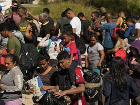FILE - Migrants wait to be processed by the U.S. Customs and Border Patrol after they crossed the Rio Grande and entered the U.S. from Mexico, Oct. 19, 2023, in Eagle Pass, Texas. A recent decline in arrests for illegal crossings on the U.S. border with Mexico may prove only temporary. The drop in January reflects how numbers ebb and flow, and the reason usually goes beyond any single factor.