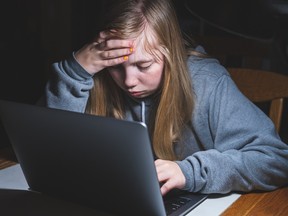 An upset girl using a computer.