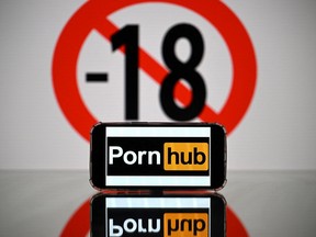 This photograph taken on May 24, 2022 in Toulouse shows screens displaying a minor child sign and the logo of the pornographic site Pornhub.