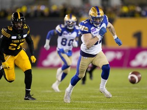 Winnipeg Blue Bombers defensive back Nick Hallett (21) and Hamilton Tiger-Cats running back Jackson Bennett (29) chase a loose ball during first half football action in the 108th CFL Grey Cup in Hamilton, Ont., on Sunday, December 12, 2021. Canadian defensive backs Nick and Noah Hallett agreed to terms on contract extensions with the Winnipeg Blue Bombers on Thursday.THE CANADIAN PRESS/Nathan Denette