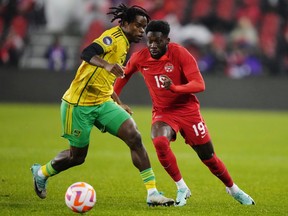 Canada's Alphonso Davies (19) moves past Jamaica's Dexter Lembikisa (2) during first half CONCACAF Nations League quarterfinal soccer action in Toronto on Tuesday, November 21, 2023. Canada fell two places to No. 50, sandwiched between Greece and Cameroon, in the latest FIFA world rankings.