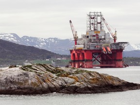 Oil rig in norwegian fjord landscape