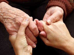 The hands of a young woman takes those of an older person