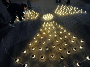 Activists and sympathizers of of environmental organisation Greenpeace Hungary light candles to form a radiation symbol in Deak Square, Budapest, on March 11, 2012 during a ceremony marking the anniversary of the Fukushima disaster.