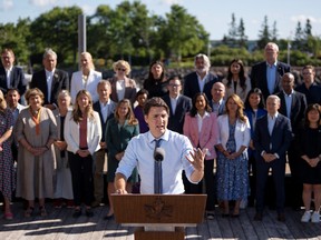 Prime Minister Justin Trudeau speaks to reporters as cabinet members look on during the Liberal cabinet retreat in Charlottetown, P.E.I. on Wednesday, August 23, 2023.
