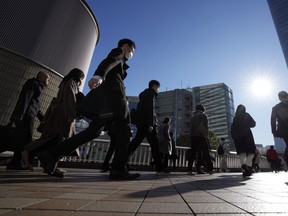 Commuters walk in a passageway during a rush hour at Shinagawa Station