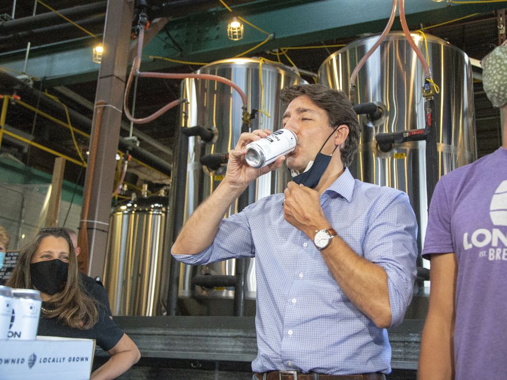 Finance Minister Chrystia Freeland, left, watches as Prime Minister Justin Trudeau samples a can of beer at the London Co-Operative Brewing Company brewery in London, Ont., in 2021.