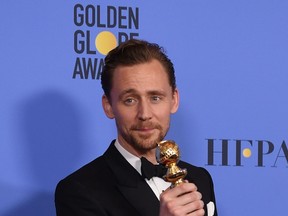 Tom Hiddleston holding a Golden Globe award