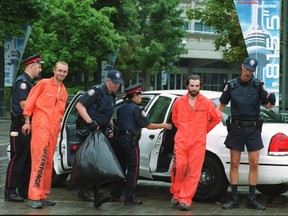 Two Greenpeace activists — Chris Holden, left, and Steven Guilbeault — are taken into custody by Toronto police after the environmentalists scaled the CN Tower in July 2001.