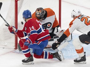 Montreal Canadiens' Nick Suzuki (14) scores on Philadelphia Flyers goaltender Samuel Ersson (33) as Flyers' Ronnie Attard (23) tries to defend during first period NHL hockey action in Montreal on Thursday, March 28, 2024.