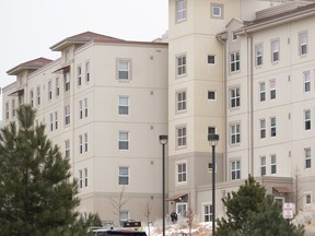 A police officer stands outside a dorm in the Village at Alpine Valley housing, Feb. 16, 2024, as police investigate a shooting on the University of Colorado Colorado Springs campus in Colorado Springs, Colo. The Colorado university where a student is charged with killing his suitemate and another person in a dorm room last month has hired two former U.S. attorneys to review of what led to the shooting and whether any campus policies and procedures can be improved. The University of Colorado Colorado Springs confirmed Monday, March 25 that John Suthers and Jason Dunn will lead the review.
